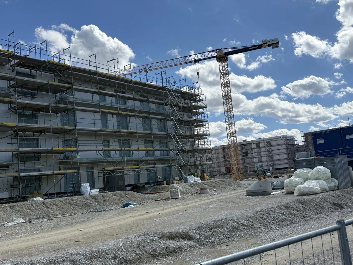 Rohbau eines Wohngebäudes mit Gerüst und Kran